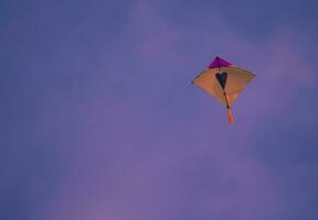 yellow and purple kite in the sky photo