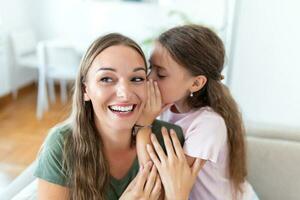 Close up image amazed mother hears incredible news from little daughter, kid girl share secret telling something interesting while mom open mouth feels surprised, trust, confidant person, fun concept photo