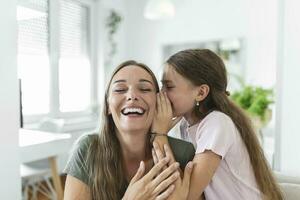 Close up image amazed mother hears incredible news from little daughter, kid girl share secret telling something interesting while mom open mouth feels surprised, trust, confidant person, fun concept photo