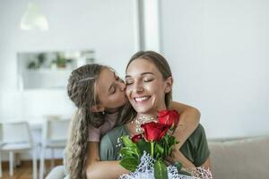 I love my you mom. Attractive young woman with little cute girl are spending time together at home, thanking for handmade card with love symbol and flowers. Happy family concept. Mother's day. photo