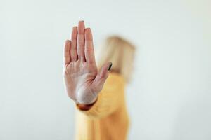 mujer elevado su mano para disuadir, Campaña detener violencia en contra mujer. rubio mujer elevado su mano para disuadir con Copiar espacio foto