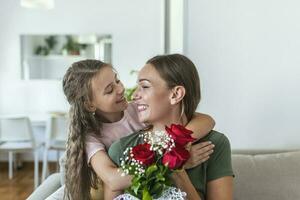 I love my you mom. Attractive young woman with little cute girl are spending time together at home, thanking for handmade card with love symbol and flowers. Happy family concept. Mother's day. photo