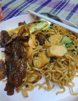 Very delicious fried noodles with toppings of sausage and vegetables and beef teriyaki. photo