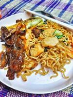 Very delicious fried noodles with toppings of sausage and vegetables and beef teriyaki. photo