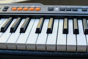 de cerca de piano llaves. piano negro y blanco llaves y piano teclado musical instrumento metido a el hogar balcón durante soleado día. foto