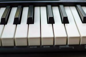 de cerca de piano llaves. piano negro y blanco llaves y piano teclado musical instrumento metido a el hogar balcón durante soleado día. foto