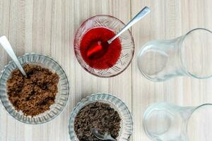 Ingredients of sundae dish as a part of non fire cooking which includes vanilla ice cream, brownie, coco powder, freshly chopped fruits and strawberry syrup. Preparation of sundae dish photo