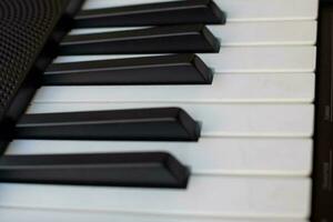 de cerca de piano llaves. piano negro y blanco llaves y piano teclado musical instrumento metido a el hogar balcón durante soleado día. foto