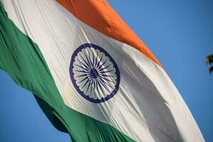 India flag flying high at Connaught Place with pride in blue sky, India flag fluttering, Indian Flag on Independence Day and Republic Day of India, tilt up shot, Waving Indian flag, Har Ghar Tiranga photo