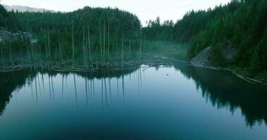 Aerial view of Elbow Lake and mountains in spring. Fog creeps over the water video