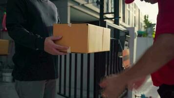 A delivery man wearing a red shirt grabs a parcel box and gives it to the customer video