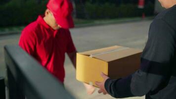 une livraison homme portant une rouge chemise attrape une parcelle boîte et donne il à le client video