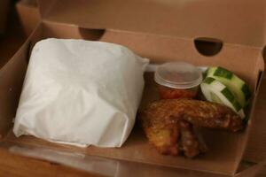 fried chicken in a box on a wooden table. photo