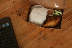 fried chicken in a box on a wooden table. photo