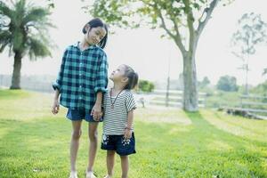 Happy Southeast Asian girls playing outdoors in the spring park. Asian children playing in the garden Summer vacation. photo