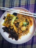 Very delicious fried noodles with toppings of sausage and vegetables and beef teriyaki. photo