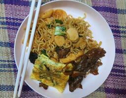 Very delicious fried noodles with toppings of sausage and vegetables and beef teriyaki. photo