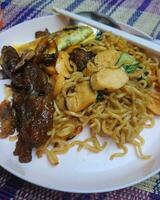 Very delicious fried noodles with toppings of sausage and vegetables and beef teriyaki. photo