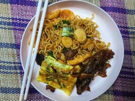 Very delicious fried noodles with toppings of sausage and vegetables and beef teriyaki. photo