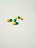aislado blanco foto de cuatro verde amarillo medicina cápsulas