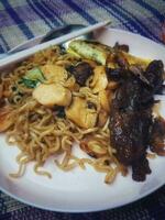 Very delicious fried noodles with toppings of sausage and vegetables and beef teriyaki. photo