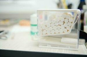 Cotton swabs inside a transparent container in the dental clinic photo