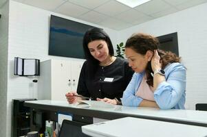 Confident dentist hygienist consults a pregnant woman about the dental treatment that needs to perform during pregnancy photo