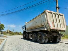 A truck carrying construction sand or concrete. The concept of reloading on the roads and renting a dump truck for work photo