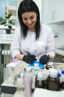 Smiling female dentist prosthetic engineer working with gypsum cast of human jaw medical laboratory of dentistry clinic photo