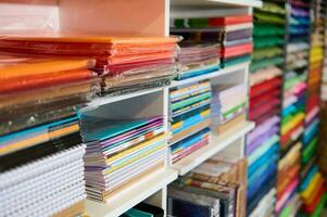 de cerca estantería con surtido de cuadernos, cuadernos de bocetos, cartulina hojas y color papel en un colegio papelería tienda foto