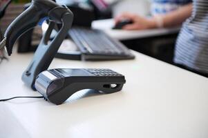 Selective focus. A countertop with credit card reader and barcode scanner in a store. photo