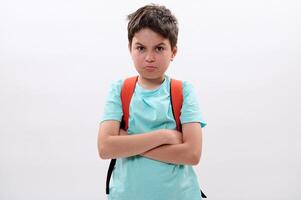 Portrait of a sad tearful schoolboy with arms folded, feeling sadness after act of bullying at school, isolated on white photo