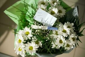 Beautiful bouquet of white chamomile with greeting card, positive pregnancy test. Happy Mother's Day. Flower arrangement photo