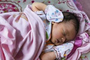 Half-body shot of a baby sleeping on a bed. photo