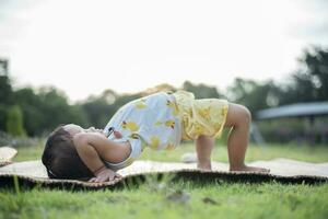 niña haciendo gimnasia en un aptitud estera solitario a hogar haciendo yoga haciendo puente natural espalda curva flexible niños haciendo gimnástico ejercicios. deporte, aprendiendo, aptitud física, extensión, activo estilo de vida concepto. foto