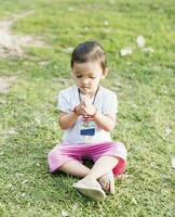 Little asian girl practicing mindfulness meditation outdoor in a park. photo