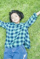 Top view of southeast asian girl lying on short grass. photo