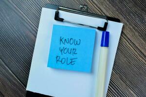 Concept of Know Your Role write on sticky notes isolated on Wooden Table. photo