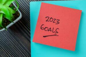 Concept of Goals 2023 write on sticky notes isolated on Wooden Table. photo