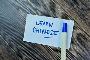 Concept of Learn Chinese write on sticky notes isolated on Wooden Table. photo