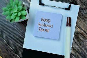 Concept of Good Business Sense write on sticky notes isolated on Wooden Table. photo