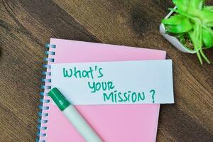 Concept of What's Your Mission write on sticky notes isolated on Wooden Table. photo