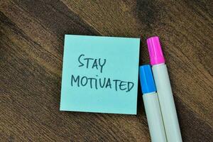 Concept of Stay Motivated write on sticky notes isolated on Wooden Table. photo