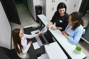 Top view happy patient and dentist standing at reception counter, prescribing treatment to perform in dentistry clinic photo