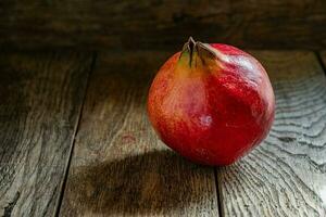 Ripe red pomegranate in on a wooden table. photo