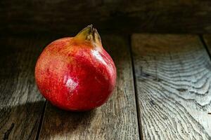 Ripe red pomegranate in on a wooden table. photo