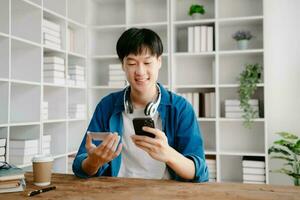 Man using smart phone for mobile payments online shopping,omni channel,sitting on table,virtual icons graphics interface screen in morning light photo