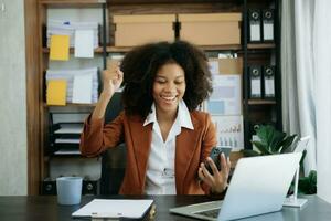 African business woman are delighted and happy with the work they do on their tablet, laptop and taking notes at office. photo