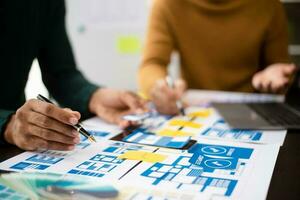 UX developer and ui designer brainstorming about mobile app interface wireframe design with customer breif and color code at modern office. photo