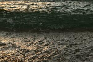 hermosa playa de arena y suave ola azul del océano foto